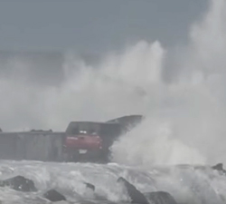man driving on jetty during big waves